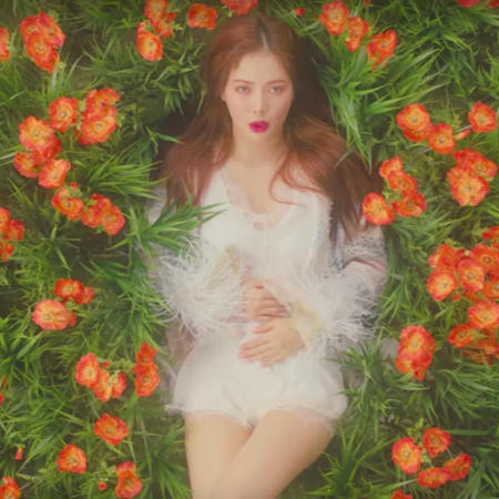 Hyuna laying in a garden of flowers